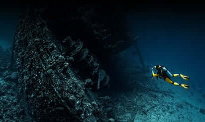 Deep sea scuba diving to examine the old ship wreak.