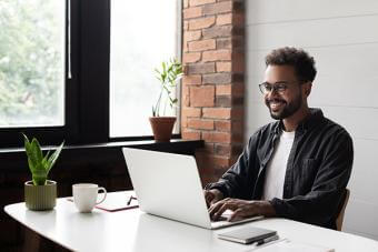 Young bearded man with glasses on laptop