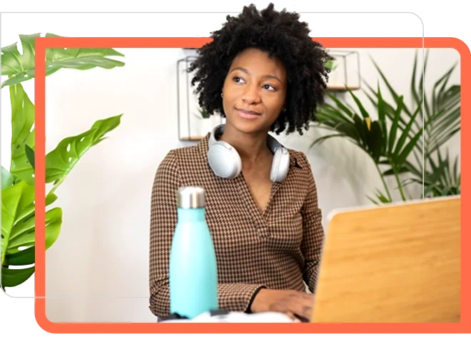 woman smile at laptop with plant and water bottle