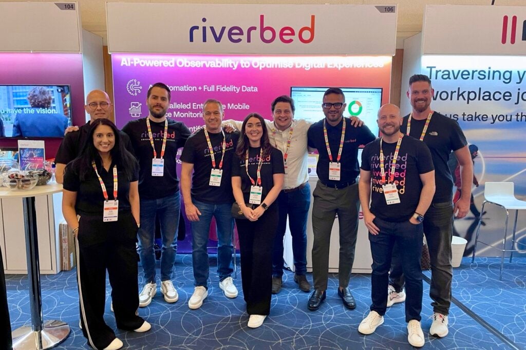 Group of people standing at Riverbed conference booth