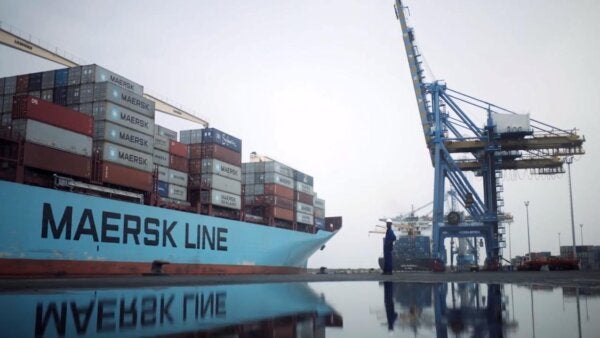 A ship in water with Maersk logo with sky-blue background